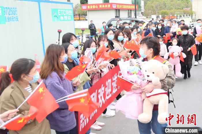 人们夹道欢迎白衣战士张杨。义乌市中心医院提供  去时千山雪归来万里春 浙江义乌援湖北白衣战士归乡