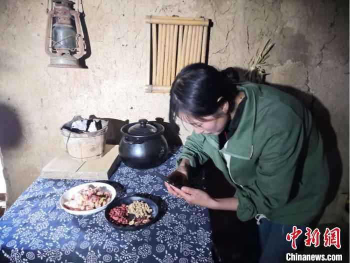 图为宕昌磨河坝村农家女,用手机录制烹饪“山味”的视频,与生活在都市的网友们分享。 后孝贤 摄  甘肃宕昌农家女引都市人“云入山”:烹山味直播荐土产