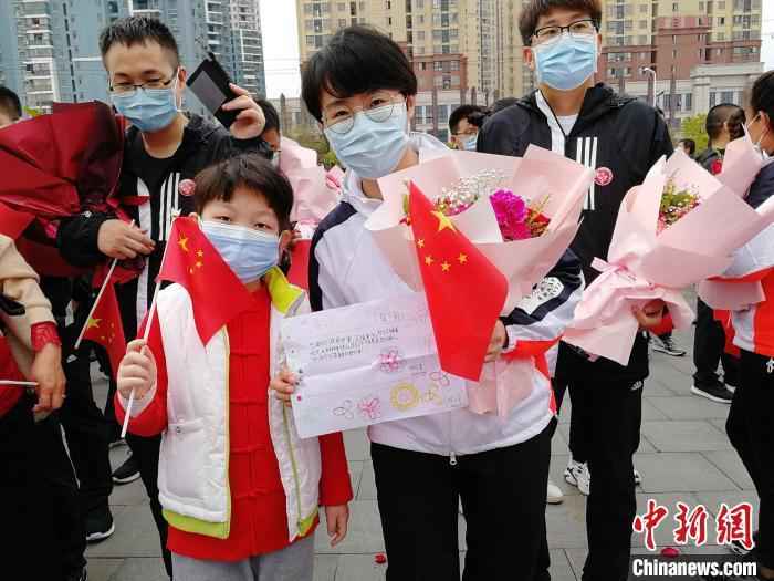 图为3月21日张静静跟随医疗队从黄冈返程时,手里拿着当地小朋友送给她的一幅画。山东大学齐鲁医院供图  山东援鄂护师张静静去世 山东卫健委:沉痛哀悼